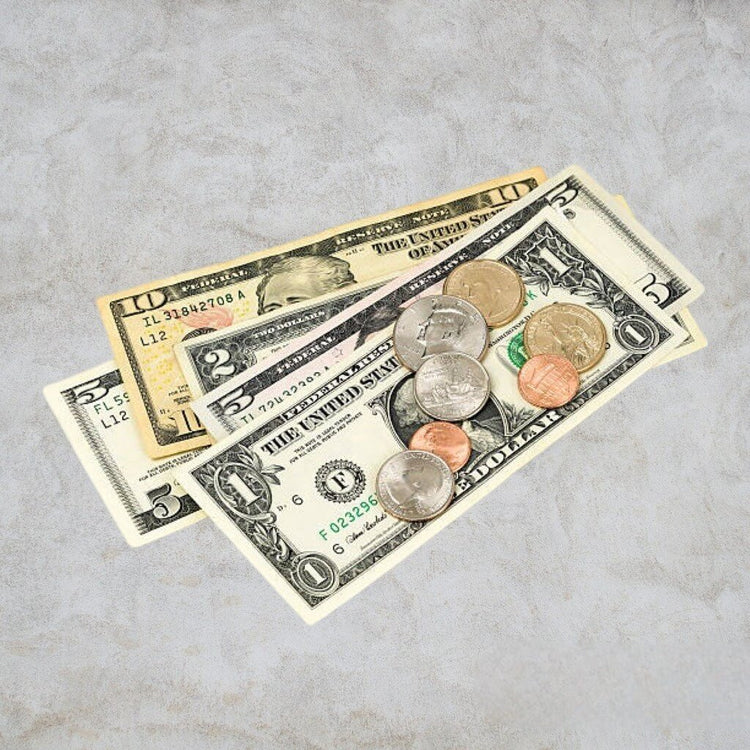 A collection of banknotes and coins stacked on a concrete background, symbolizing monetary value.