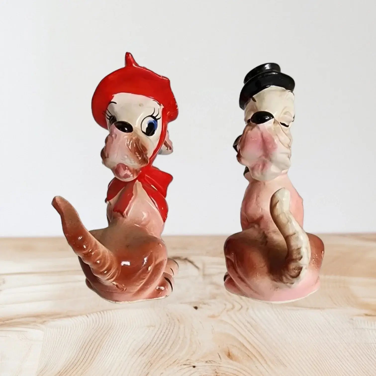 Colorful ceramic cat and dog figurines, displayed together on a shelf.