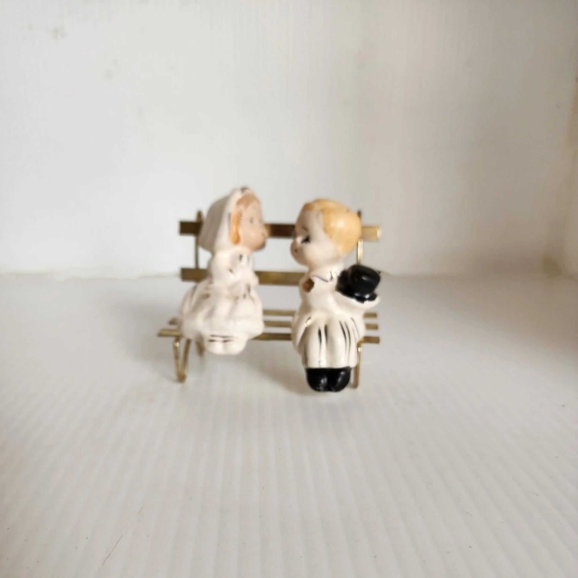 A vintage bridal couple sitting on a bench, radiating love and happiness on their special day.