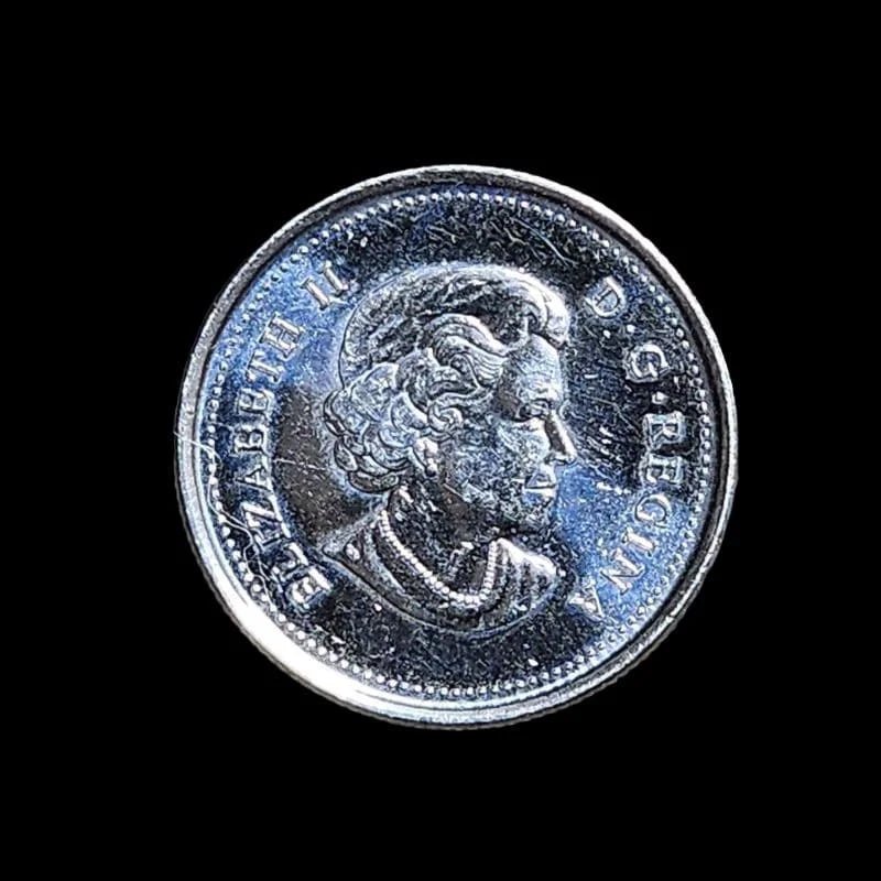 A 25 cent coin from Canada displaying the Canadian flag.