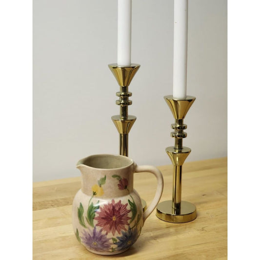 A pitcher featuring a beautiful floral design, hand-painted for a charming touch.