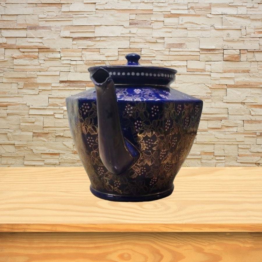 A blue teapot with gold flowers and images all over.