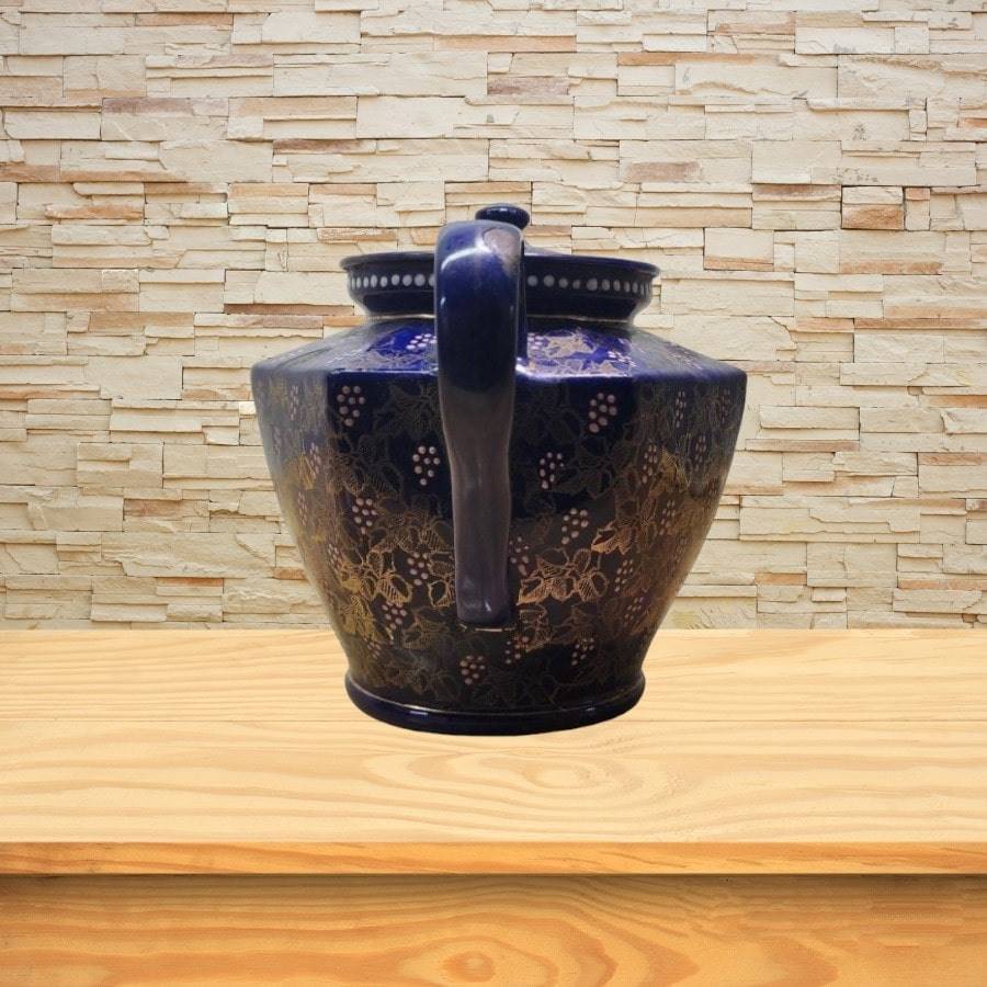 A blue teapot with gold flowers and images all over.