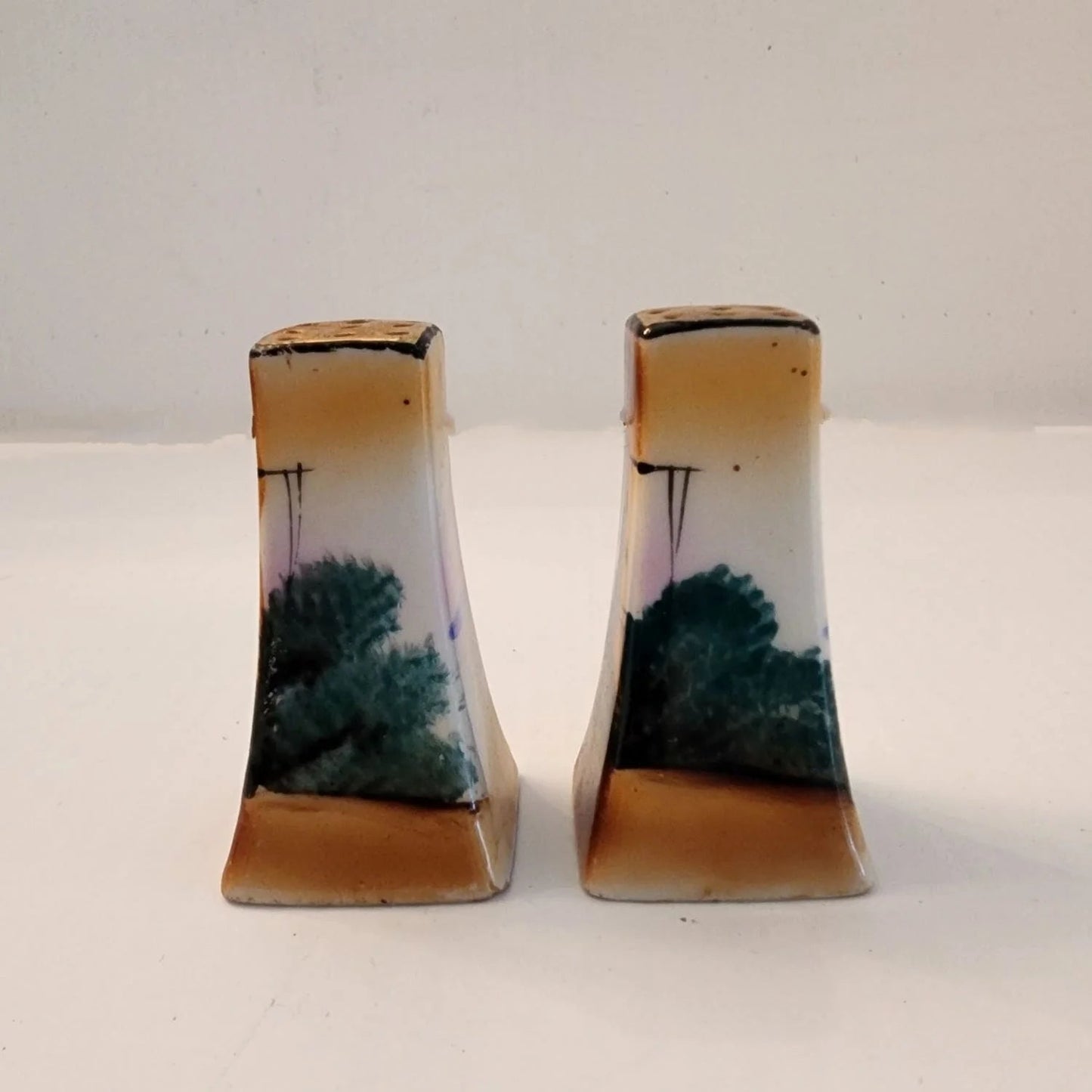 Two small salt and pepper shakers featuring a windmill design. Perfect for adding flavor to your meals.