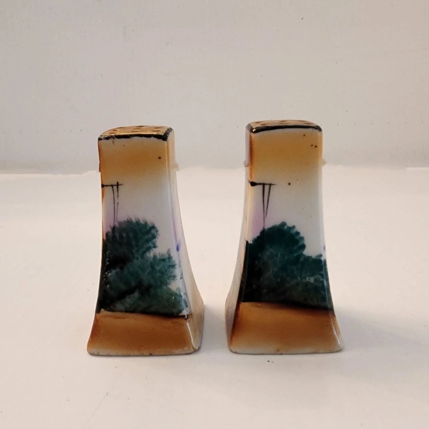 Two small salt and pepper shakers featuring a windmill design. Perfect for adding flavor to your meals.