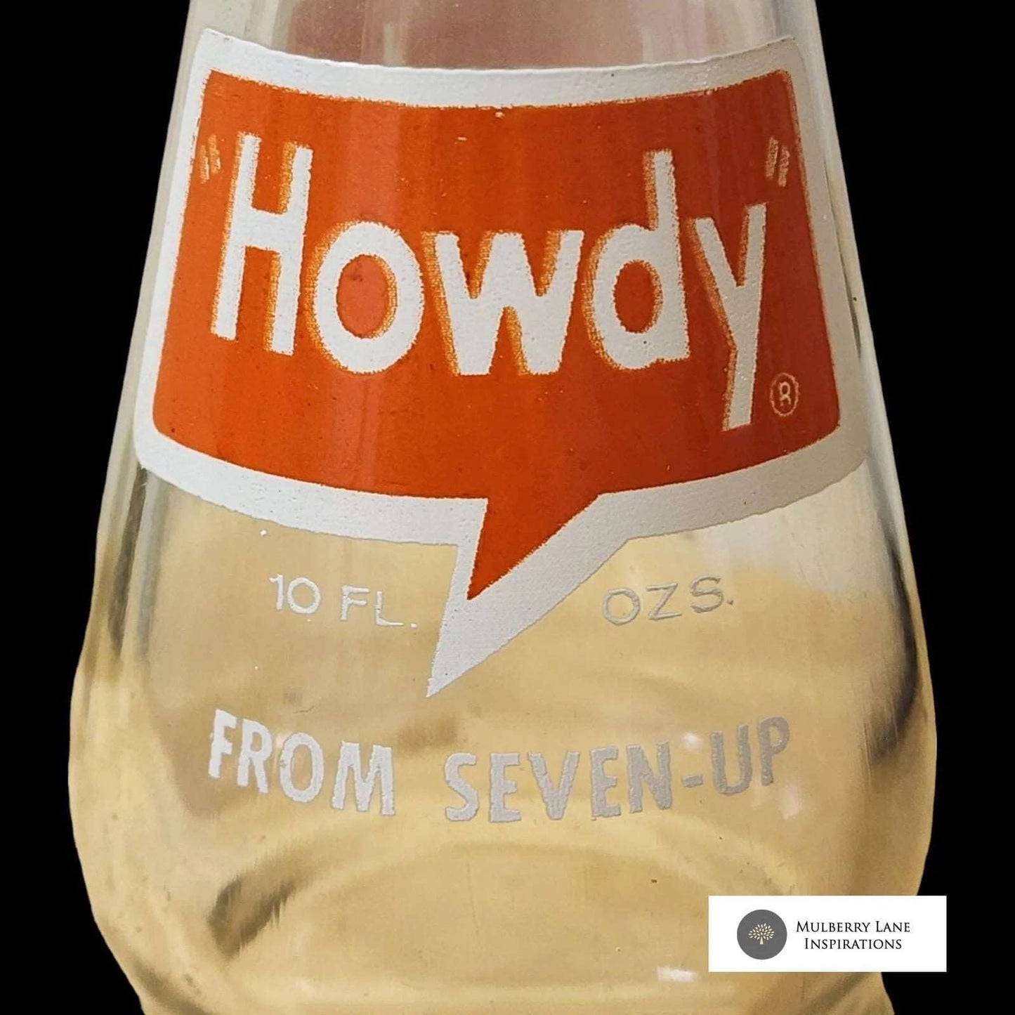 Dark backdrop featuring Howdy soda bottle.