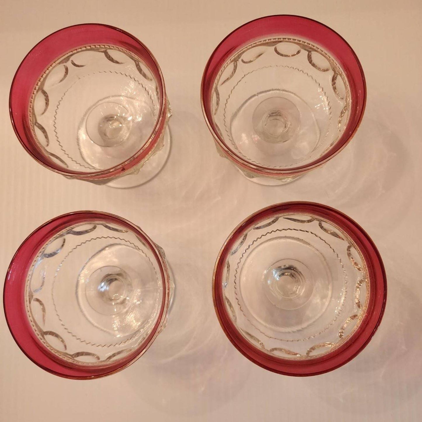 Elegant red glass bowl with a transparent base, ideal for displaying colorful treats.
