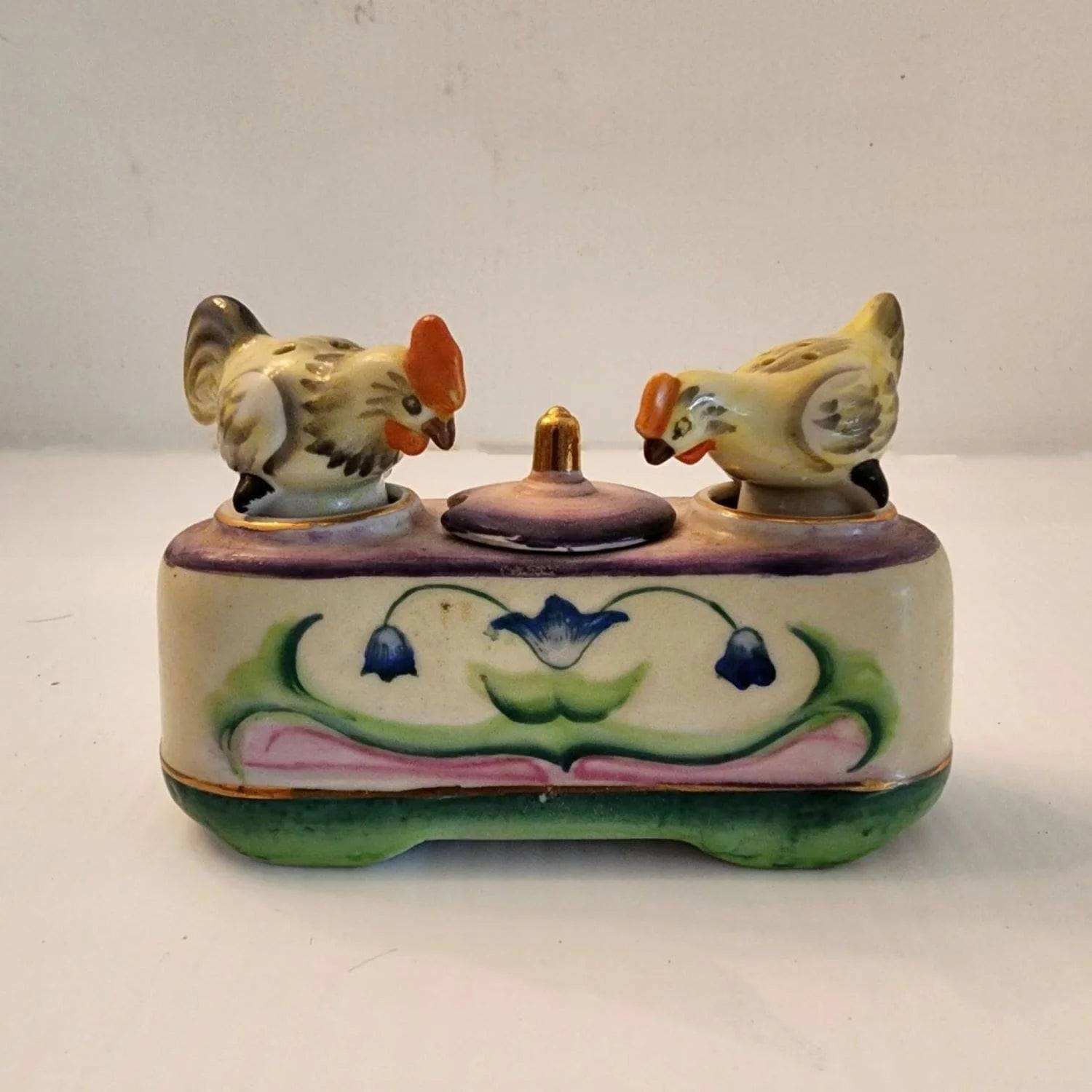 Ceramic box with two bobble birds on the top