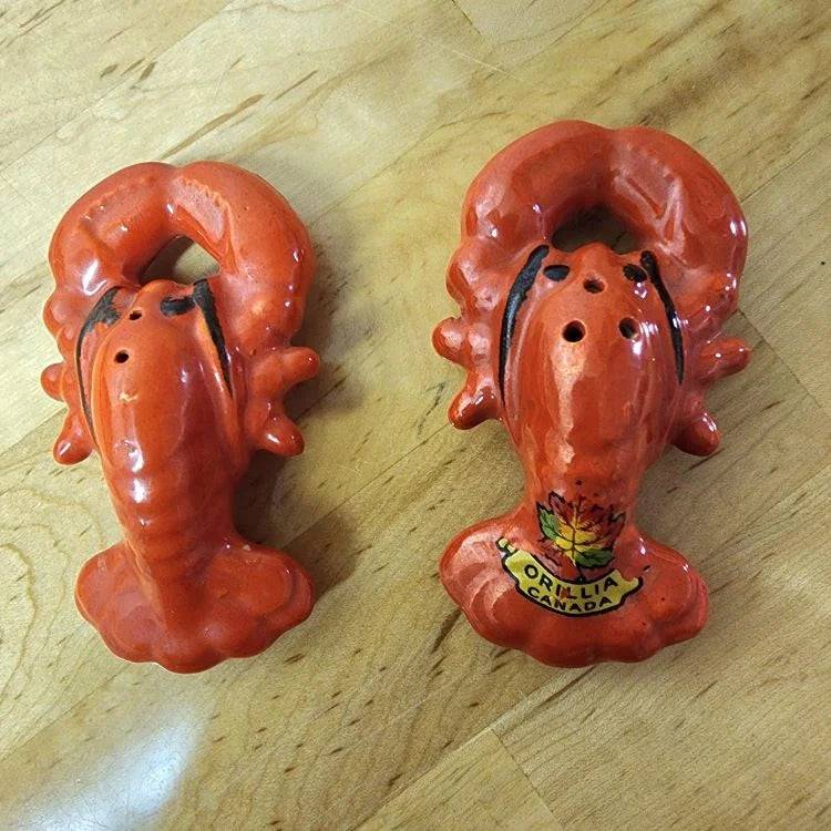 Two lobster-shaped salt and pepper shakers, perfect for adding flavor to your meals.
