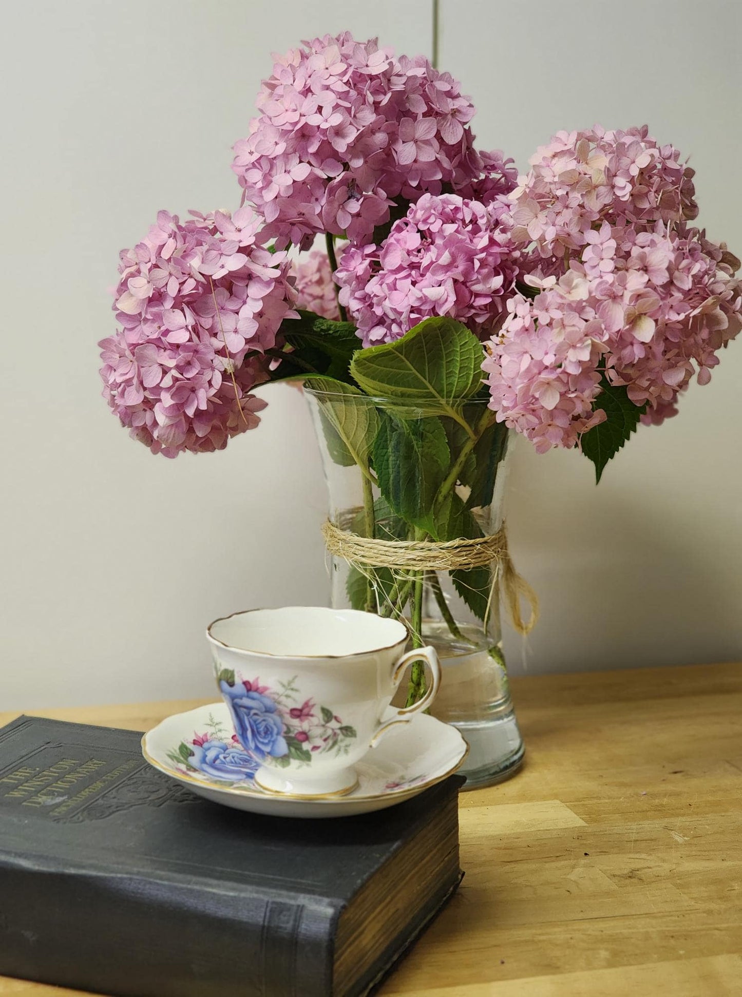 A tea cup and saucer featuring a delicate blue rose design.