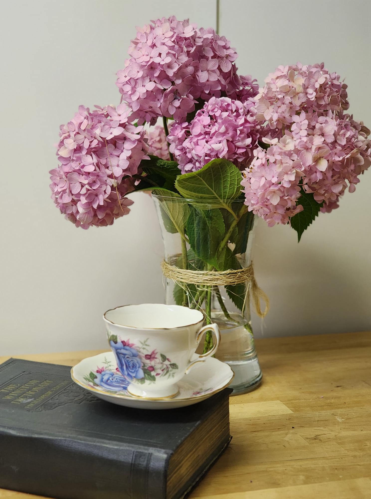 A tea cup and saucer featuring a delicate blue rose design.