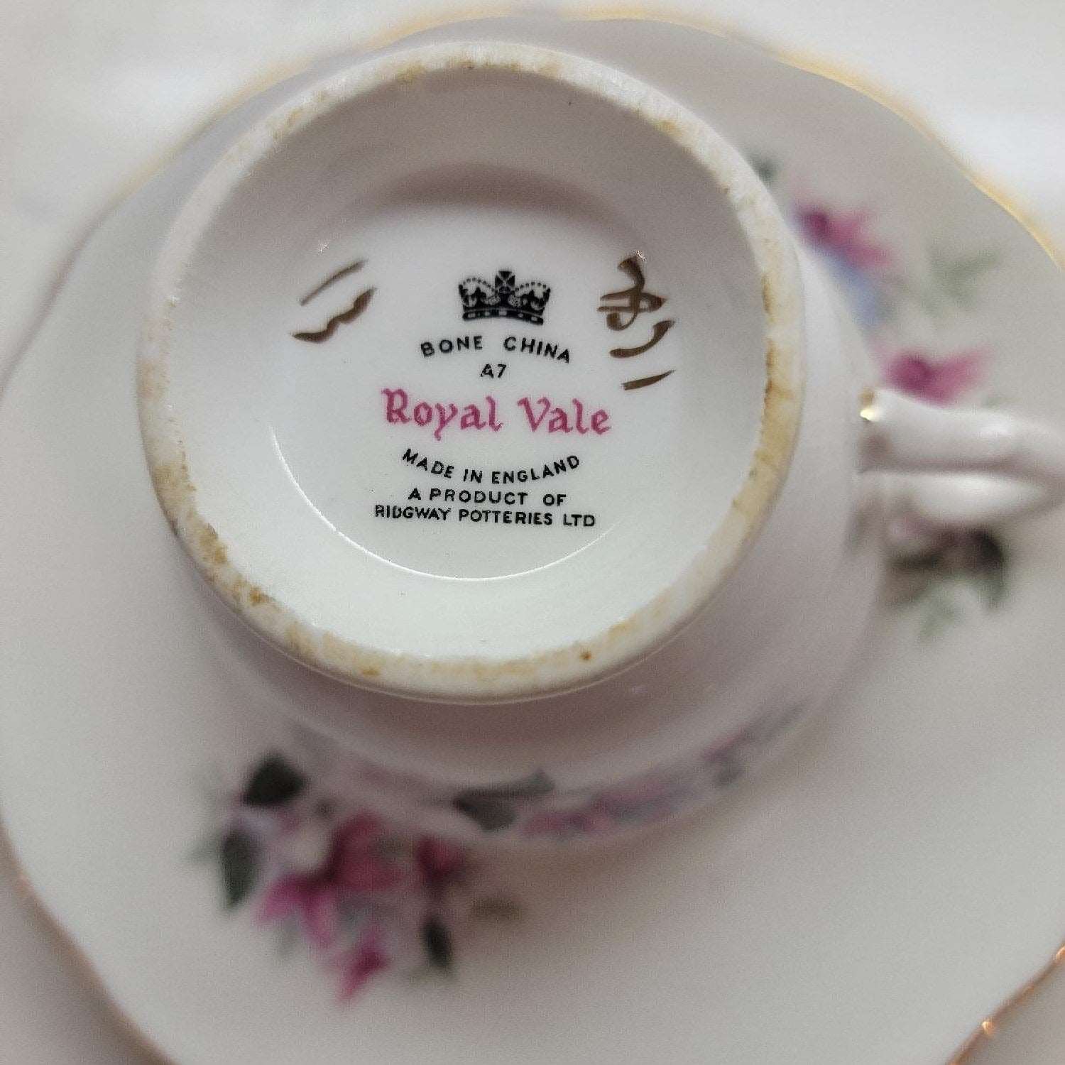 A tea cup and saucer featuring a delicate blue rose design.