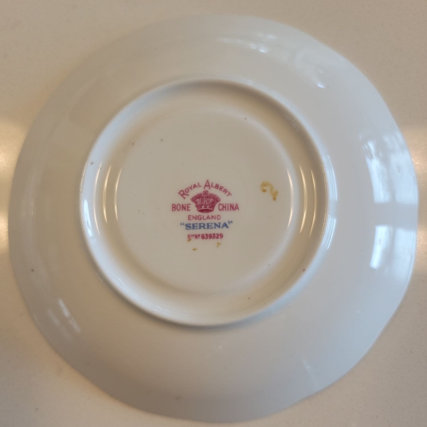 A tea cup and saucer featuring a delicate blue rose design.