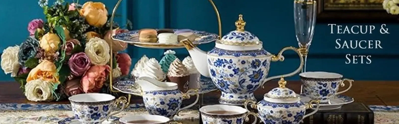 Teacups and saucer with teapot flowers and sweet treats