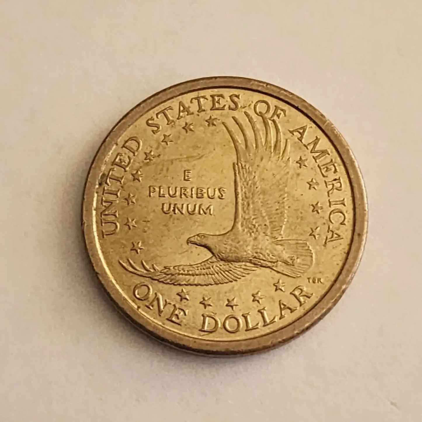 An elegant coin design showcasing a woman tenderly holding a baby, representing the essence of maternal care and devotion.