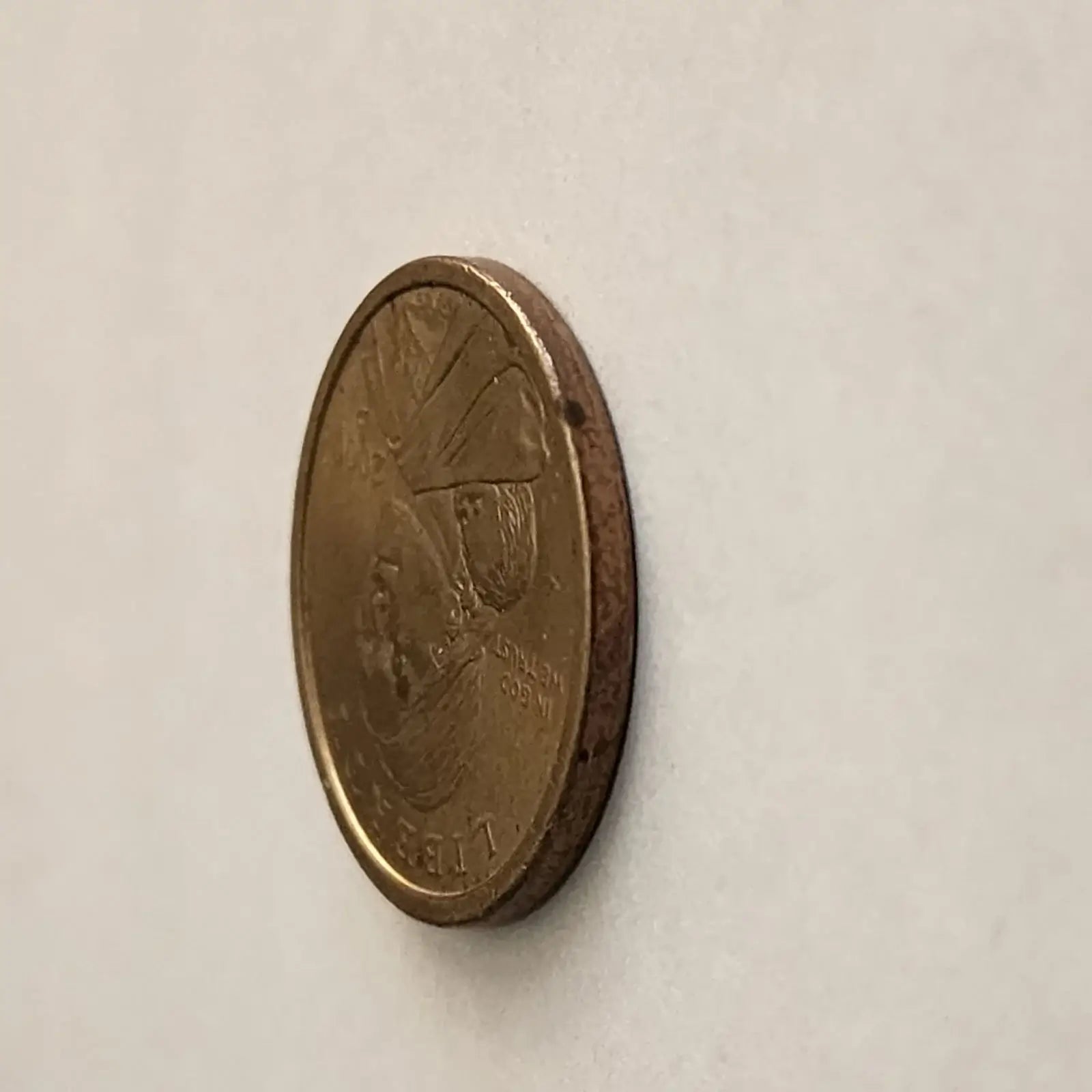 An elegant coin design showcasing a woman tenderly holding a baby, representing the essence of maternal care and devotion.