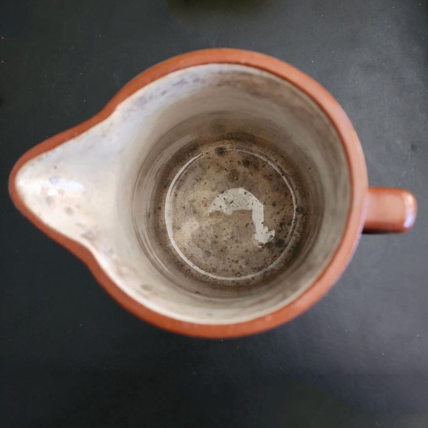 A brown jug with a handle on a white background.