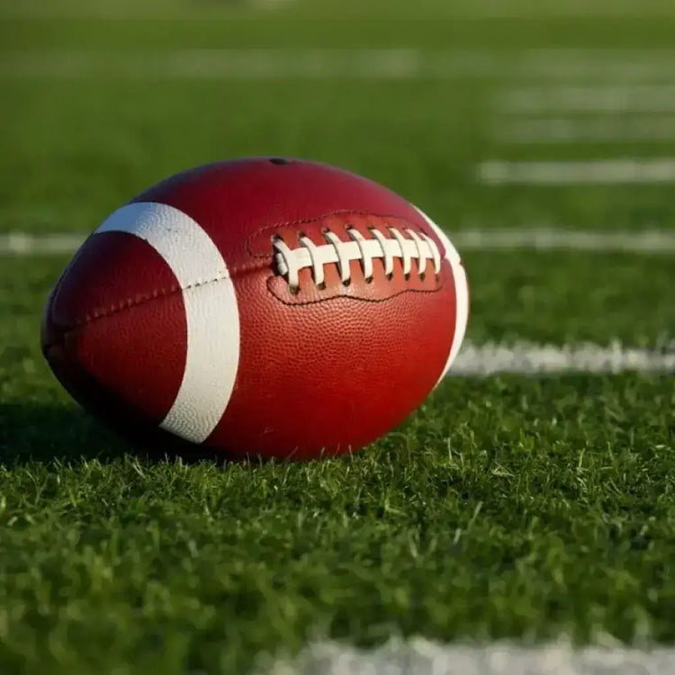 A solitary football lies on the vibrant grass of the field, poised for action in the game of champions.