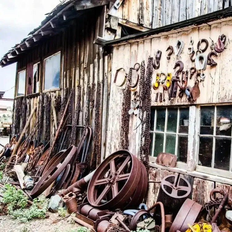 A weathered building filled with antique rusty objects, showcasing the charm of a bygone era.