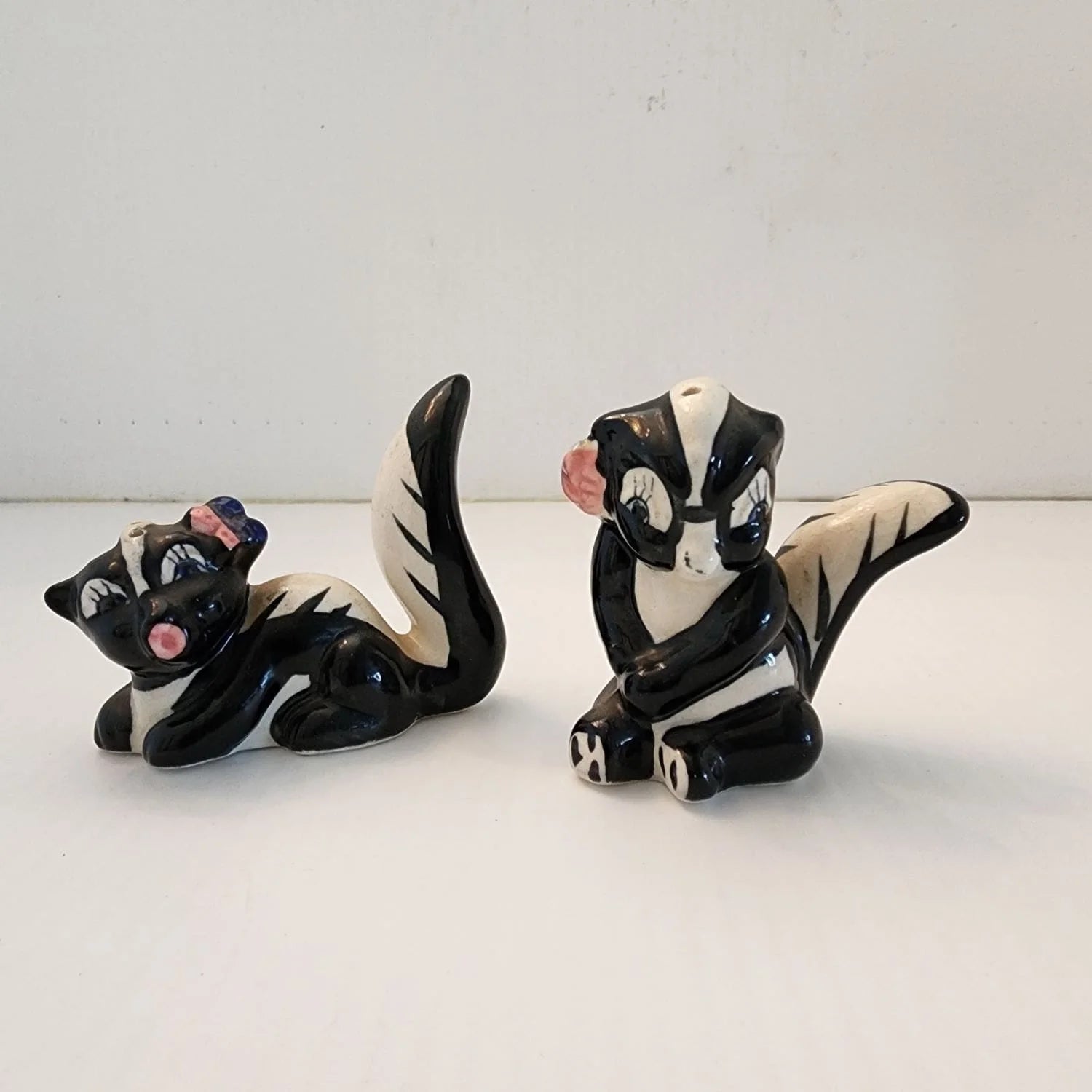 Two ceramic animals, one black and one white, sitting on a table.