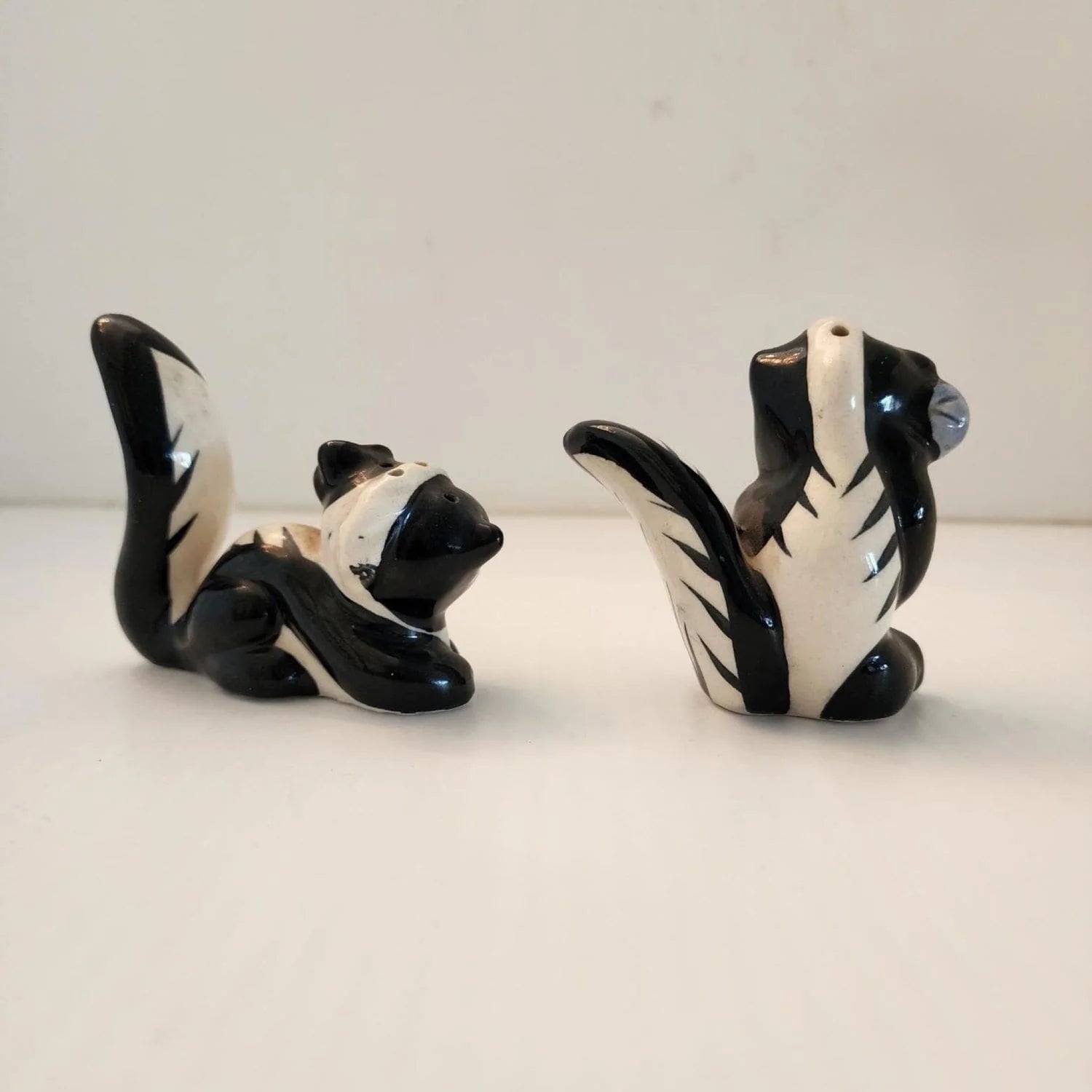 Two ceramic animals, one black and one white, sitting on a table.