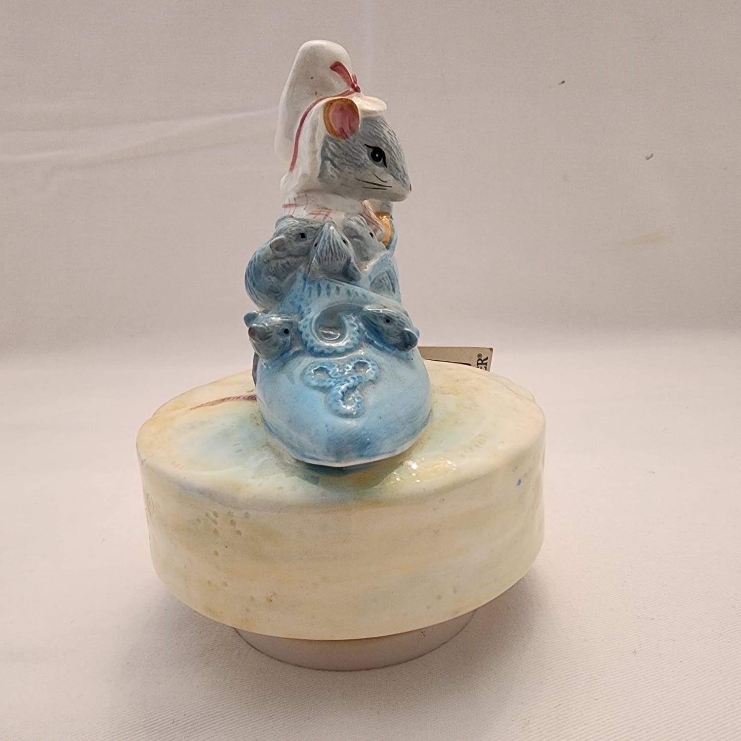 A mouse figurine perched on a shoe.