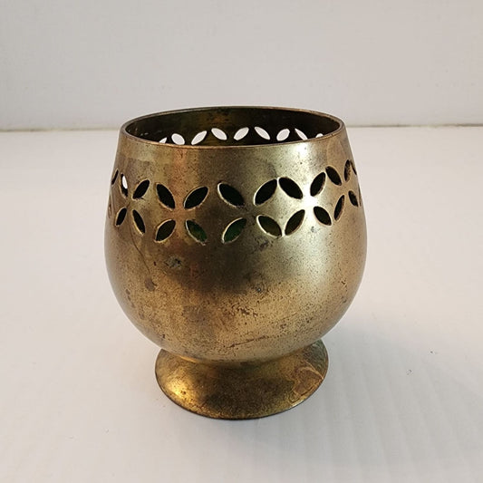 Brass candle holder featuring intricate flower design, perfect for adding elegance to any room decor.
