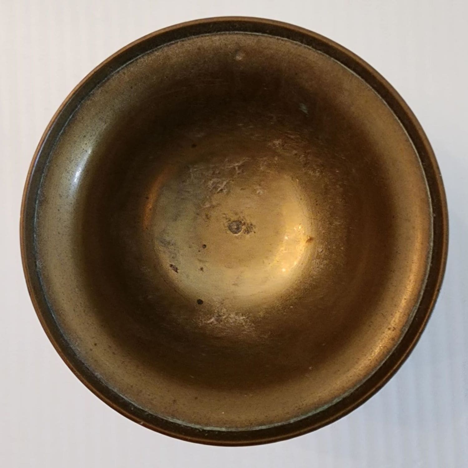A brass bowl with an intricate design etched on its surface.