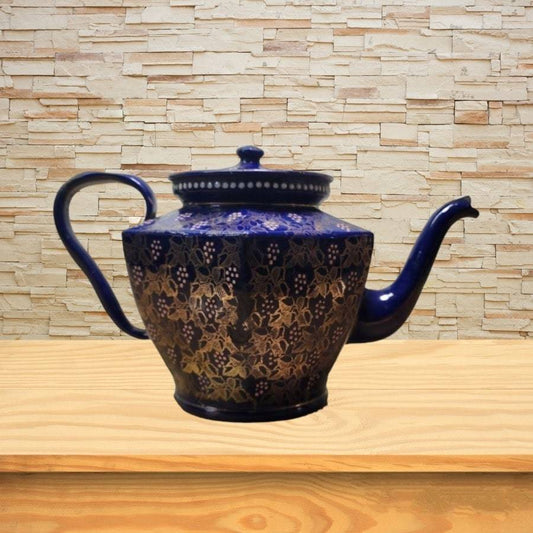 A blue teapot with gold flowers and images all over.