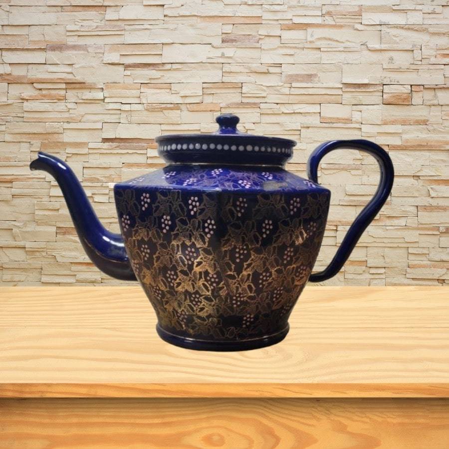 A blue teapot with gold flowers and images all over.