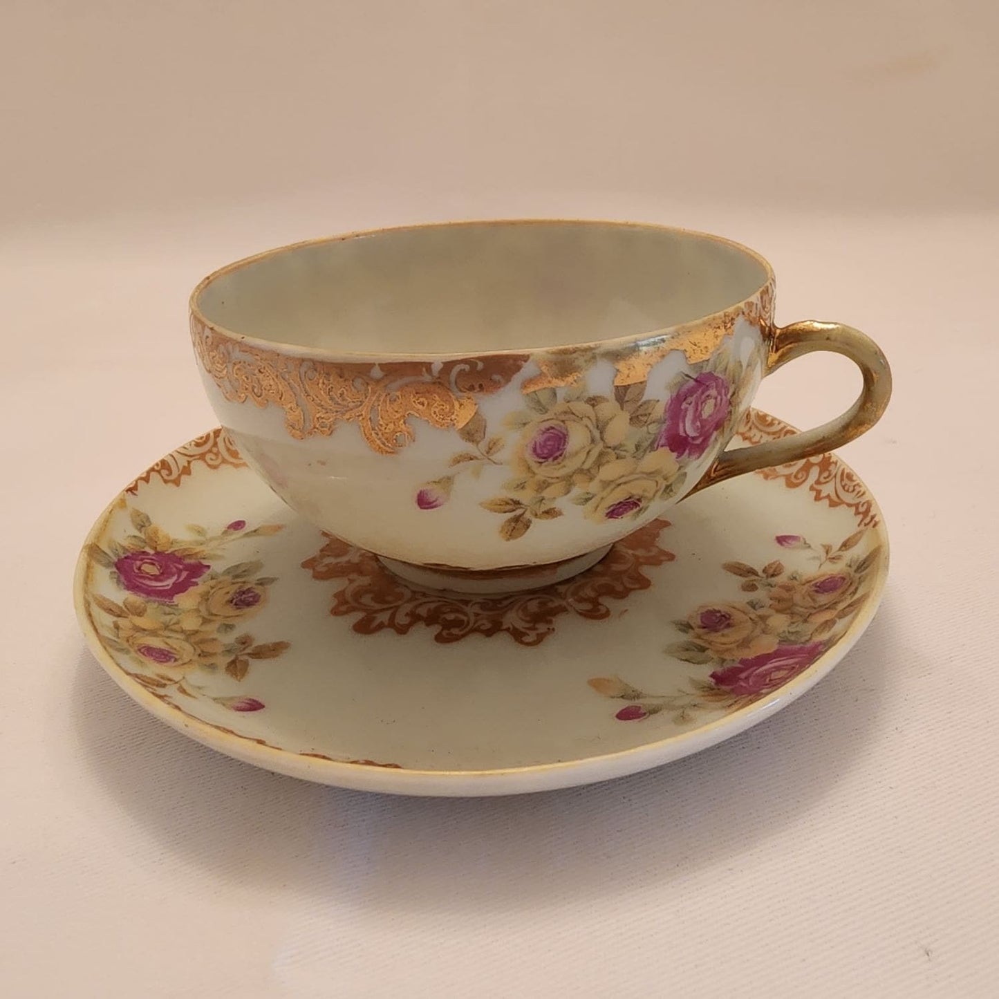 A cup and saucer with a delicate gold trim, adding an elegant touch to the table setting.