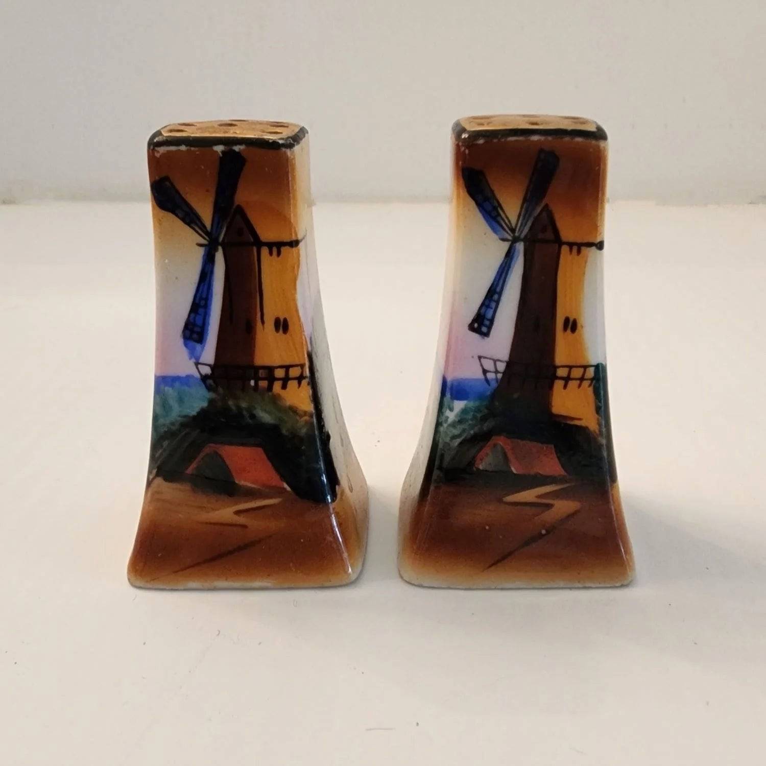 Two small salt and pepper shakers featuring a windmill design. Perfect for adding flavor to your meals.