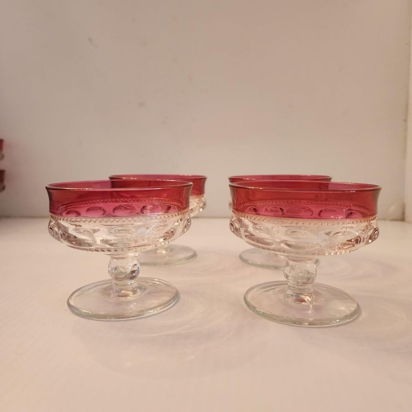 Elegant red glass bowl with a transparent base, ideal for displaying colorful treats.