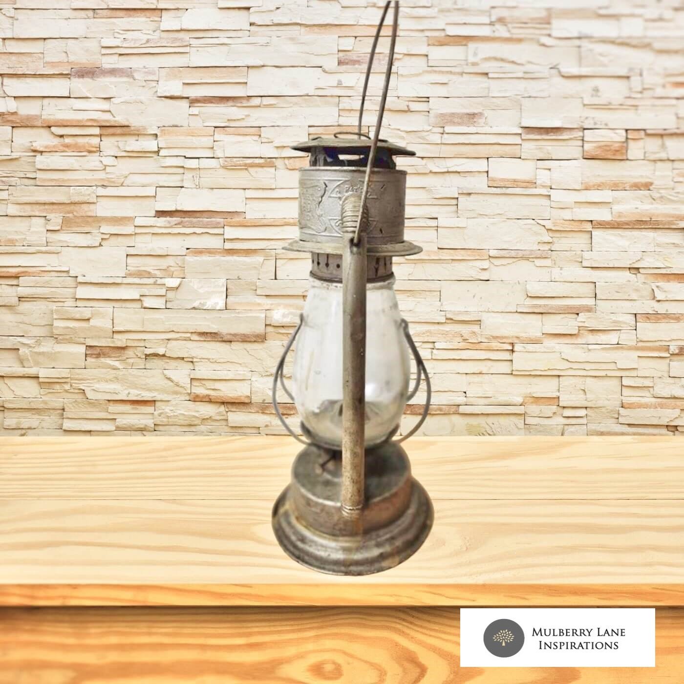 An antique lantern sits on a rustic wooden table, emanating a warm glow in a dimly lit room.