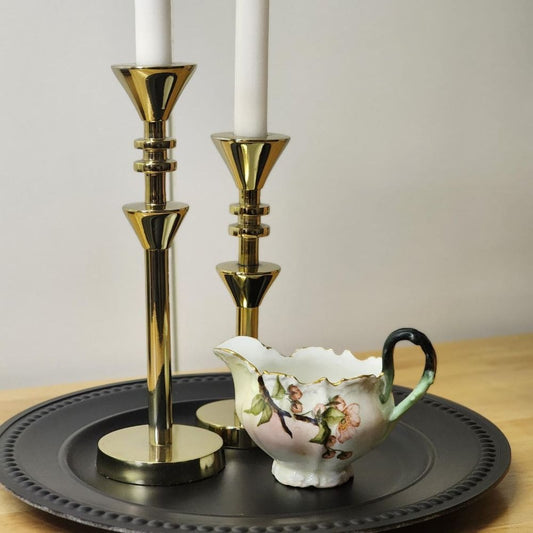 Two candles on a tray with a small cup, creating a serene ambiance.