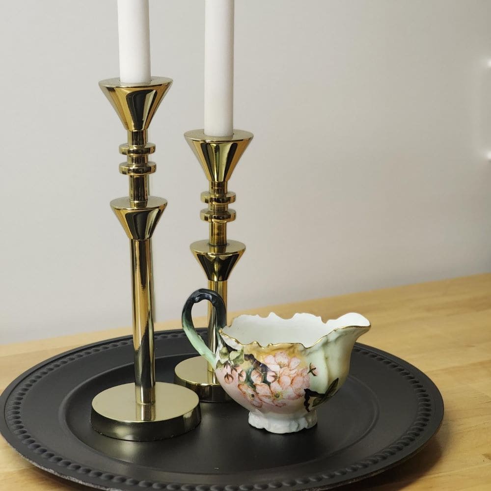 Two candles on a tray with a small cup, creating a serene ambiance.