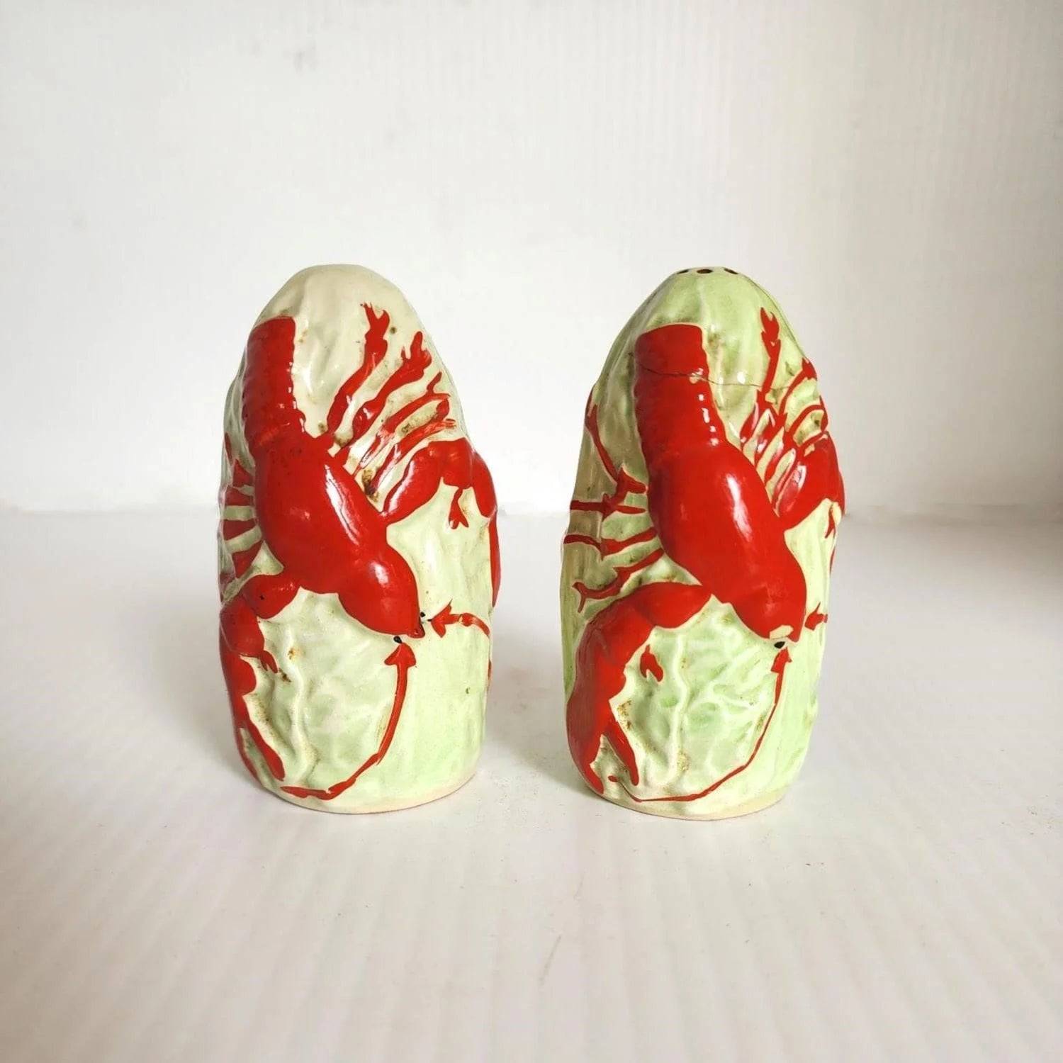 Two ceramic lobster salt and pepper shakers on a table.