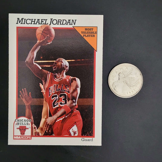 Size comparison of a Michael Jordan basketball card with a quarter.