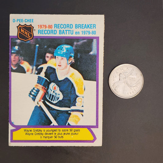 An image showing a coin and a hockey card positioned closely together.