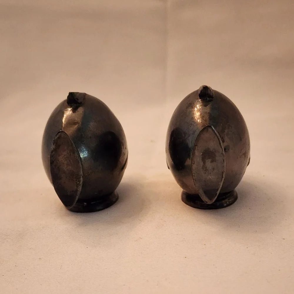 Pair of black fish salt and pepper shakers on a white surface.