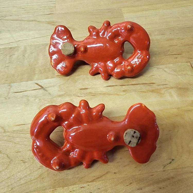 Two lobster-shaped salt and pepper shakers, perfect for adding flavor to your meals.