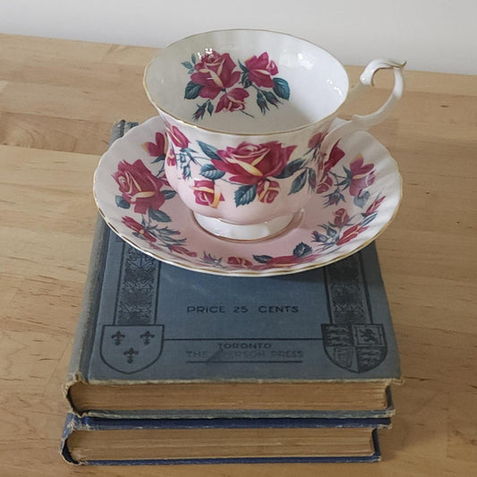 A tea cup and saucer resting on a stack of books, creating a cozy and intellectual ambiance.