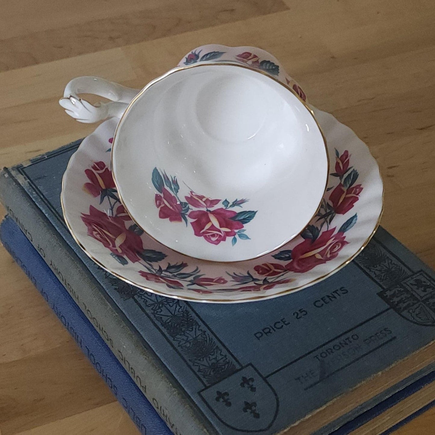 A tea cup and saucer resting on a stack of books, creating a cozy and intellectual ambiance.