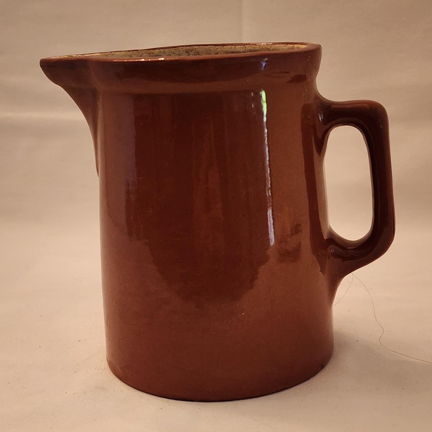 A brown jug with a handle on a white background.